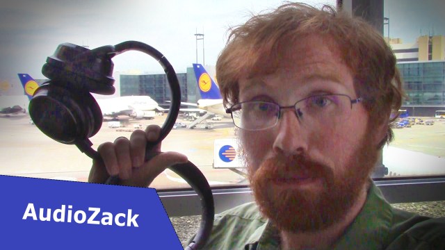 AudioZack holding headphones at an airport
